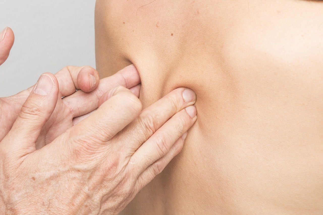 Das Bild zeigt eine Person, die eine körpertherapeutische Behandlung im Bereich des Schulterblatts erhält.